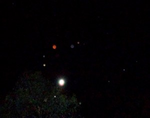 Two orb groups, one at lower right positioning themselves in a straight line, the other forming an arch over the Full Moon, Nov. 26, 2015.